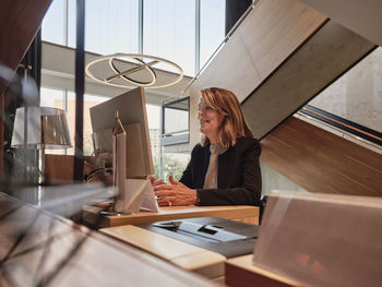 Woman using phone while sitting on table