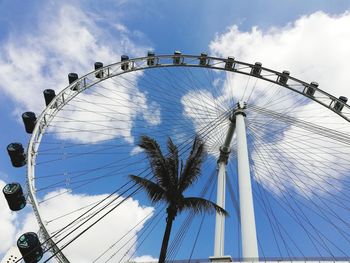 Low angle view of ferris wheel against cloudy sky