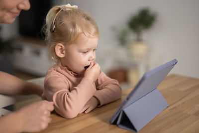 Close-up of boy using laptop at home