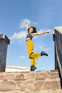 Young woman dancing on top of stone steps