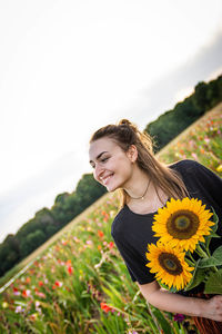 Portrait of a smiling young woman standing in field
