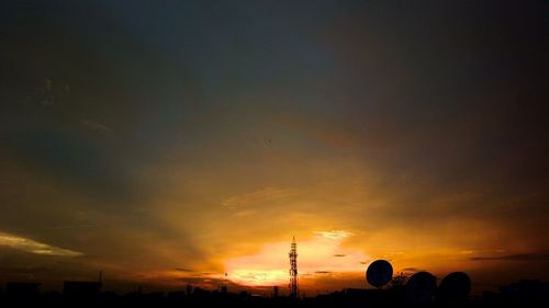 Silhouette of city against sky during sunset