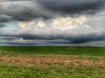 Scenic view of field against cloudy sky