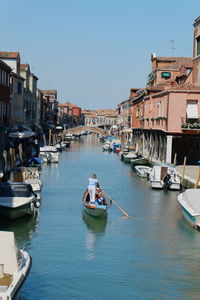 Boats moored in water against clear sky