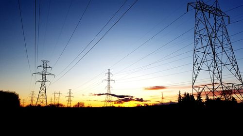 Electricity pylon against sky at sunset