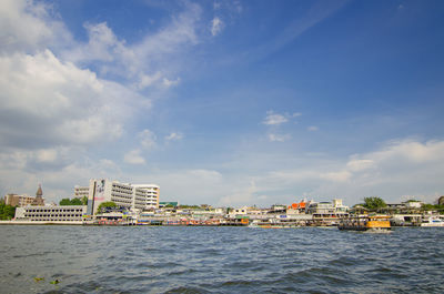 Sea by buildings against sky