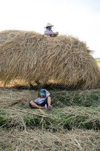 Man working on hay bales in field