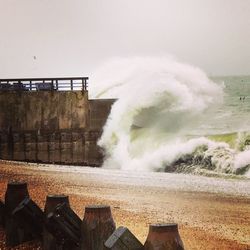 Waves on shore against sky