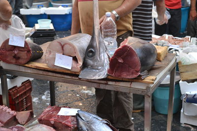 Man and fish for sale in market