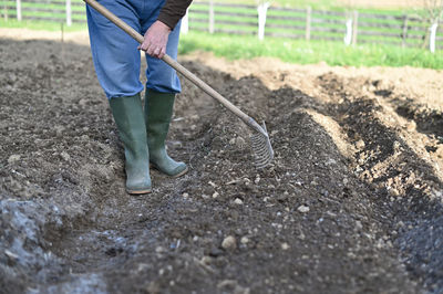 Low section of man standing in mud