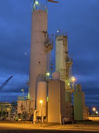Low angle view of illuminated  cryo  plant against sky at dusk