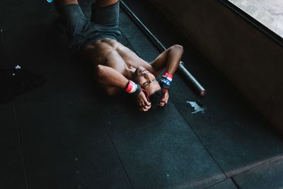 High angle view of shirtless man exercising on floor