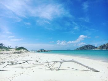 View of calm beach against cloudy sky