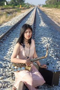 Woman sitting on railroad track