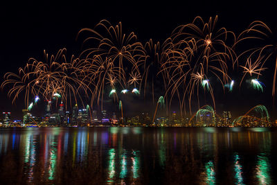 Firework display over river at night