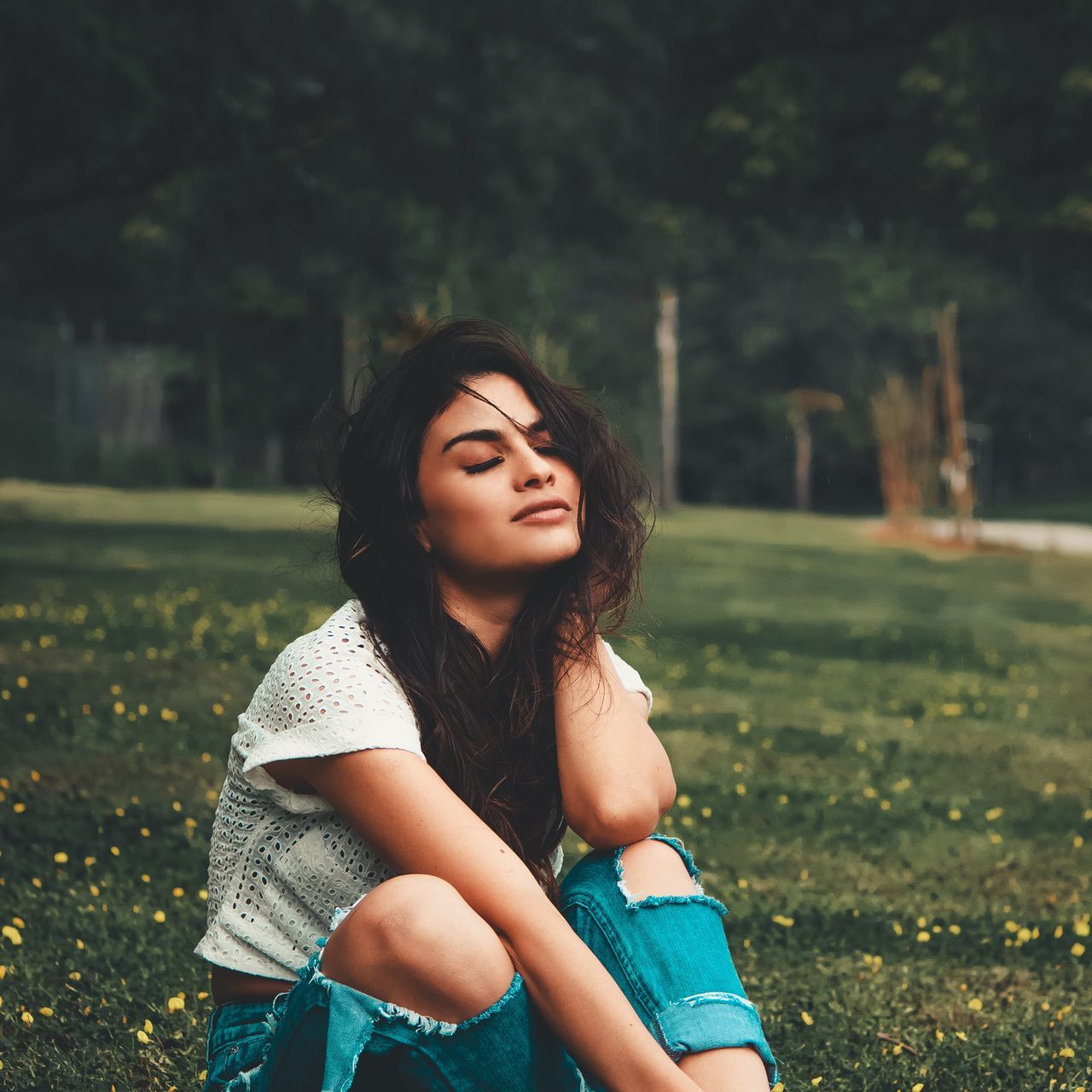 BEAUTIFUL YOUNG WOMAN SITTING ON LAND