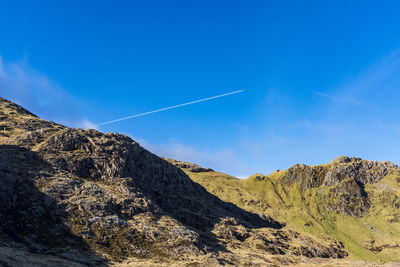 Scenic view of mountains against blue sky