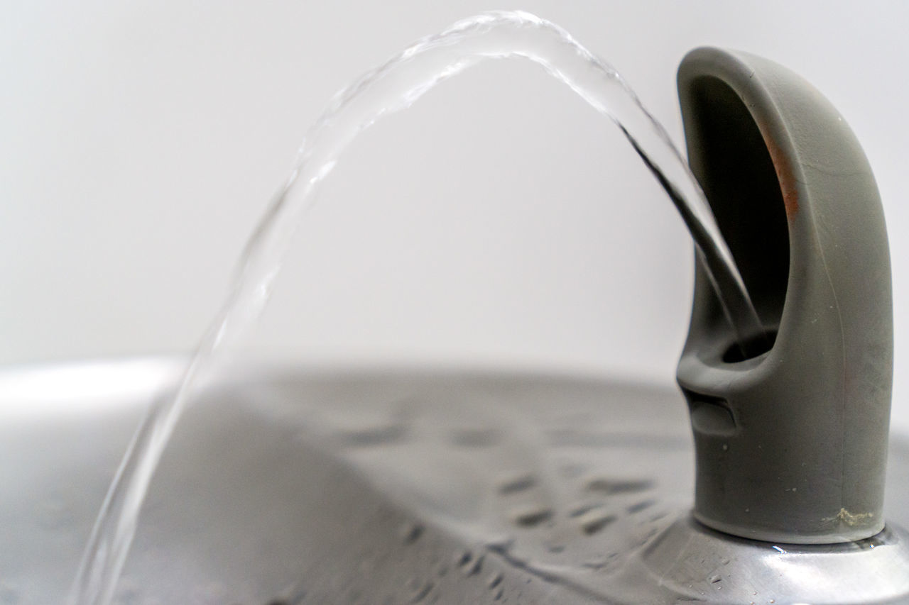 CLOSE-UP OF DRINKING GLASS ON WHITE BACKGROUND