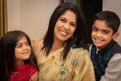 Portrait of smiling mother with daughter and son at home