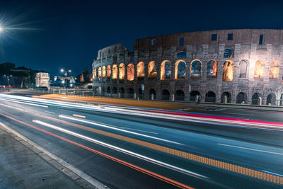 Light trails on street against buildings in city at night