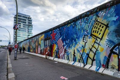 Graffiti on wall in city against sky