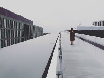 Rear view of woman standing on the roof of an office building