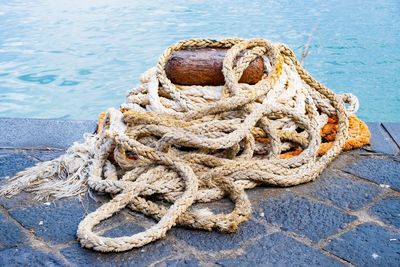 High angle view of rope tied to bollard at harbor