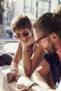 Mid adult man and young woman looking at menu while sitting in cafe