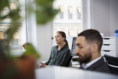 Male and female coworkers sitting in meeting at office