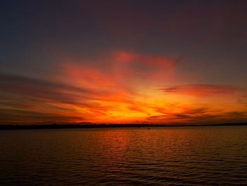 Scenic view of sea against dramatic sky during sunset