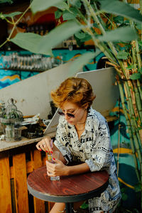 Woman having coffee while sitting on chair at table