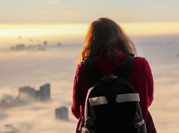 Rear view of woman looking at sea during sunset