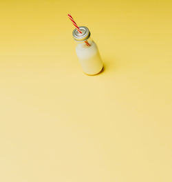 High angle view of wineglass on yellow background