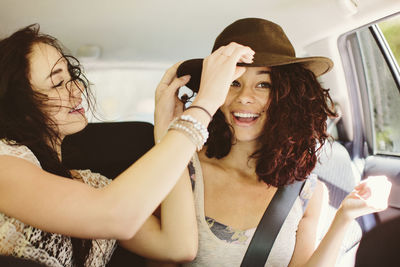 Happy female friends traveling in car