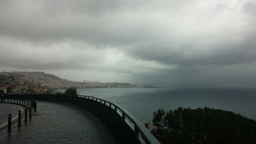 Bridge over river against cloudy sky