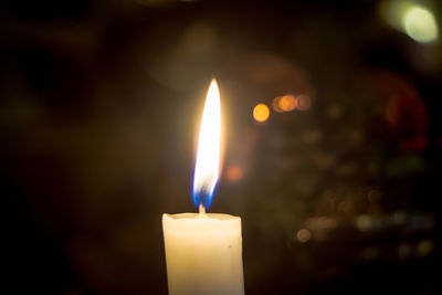 Close-up of burning candle in darkroom