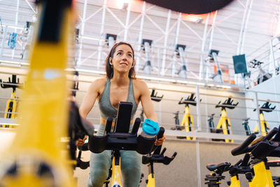 Young athlete on cardio bike in modern gym