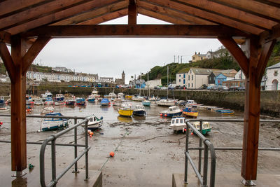 Boats moored in restaurant by buildings against sky