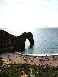 Scenic view of cliff by sea against sky