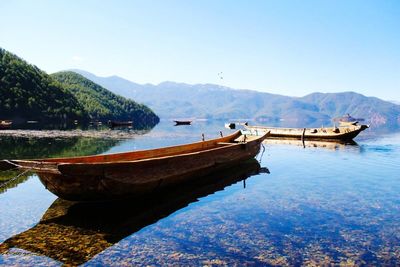 Boat moored on lake against sky