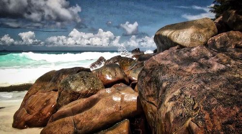 Close-up of rocks by sea against sky