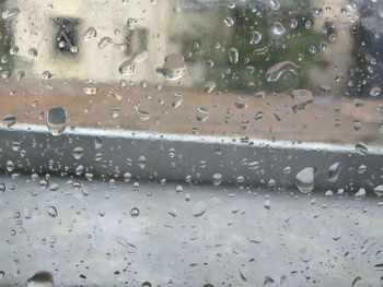 Close-up of wet car window during rainy season