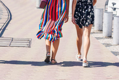 Low section of women walking on footpath