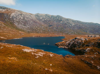 Scenic view of lake by mountain against sky