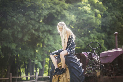 Rear view of woman standing against trees