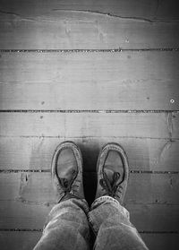 Low section of man standing on floorboard