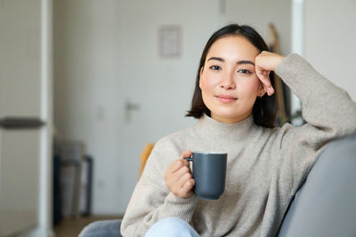 Young woman using mobile phone at home