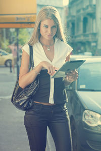 Midsection of woman with arms raised in city