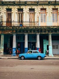 Vintage car parked on road against residential building