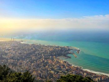 High angle view of city by sea against sky